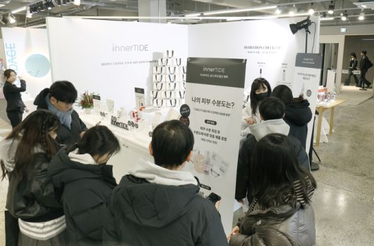 ‘이너타이드’의 팝업 스토어에 많은 방문객이 몰려 피부수분도를 측정하고 있다.