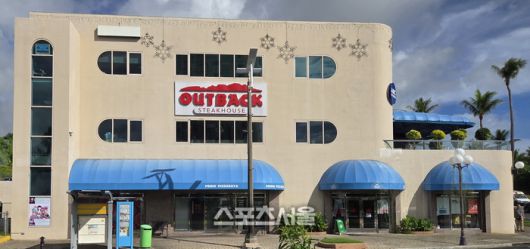 괌 투몬 거리 한복판에서 만난 아웃백 스테이크하우스. 이국적인 야자수와 어우러진 익숙한 브랜드 간판이 한국 여행객들에게 묘한 반가움을 선사한다. 괌 | 원성윤 기자 socool@sportsseoul.com