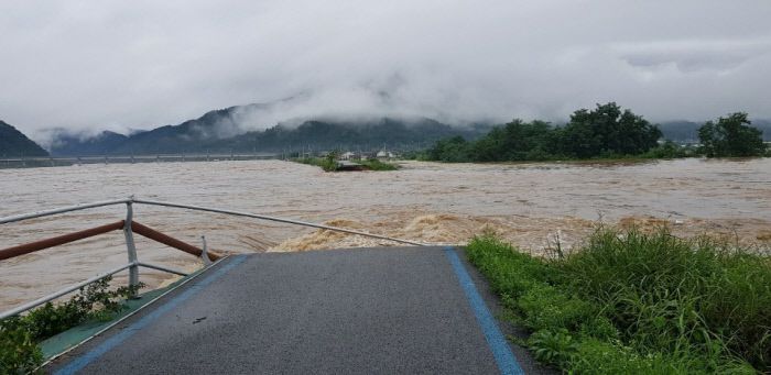 8일 낮 12시50분쯤 남원시 금지면 귀석리 금곡교 인근 섬진강 제방이 붕괴돼 물이 쏟아져 들어오고 있는 모습. 전북소방본부 제공