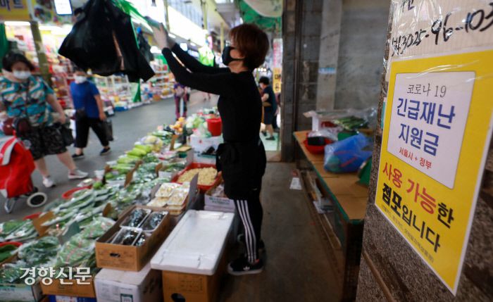 서울 마포구 망원시장의 한 상점에 긴급재난지원금을 사용할 수 있는 점포라는 것을 알리는 알림판이 24일 붙어 있다.  우철훈 선임기자 photowoo@kyunghyang.com