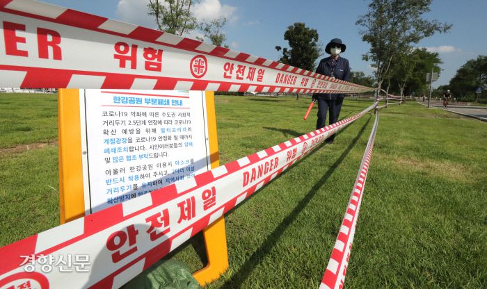 한강시민공원도 부분폐쇄 서울시 관계자가 8일 코로나19 확산 방지를 위해 사람들이 많이 몰리는 한강시민공원 일부 밀집지역에 통제선을 설치한 후 순찰을 돌고 있다. 권호욱 선임기자