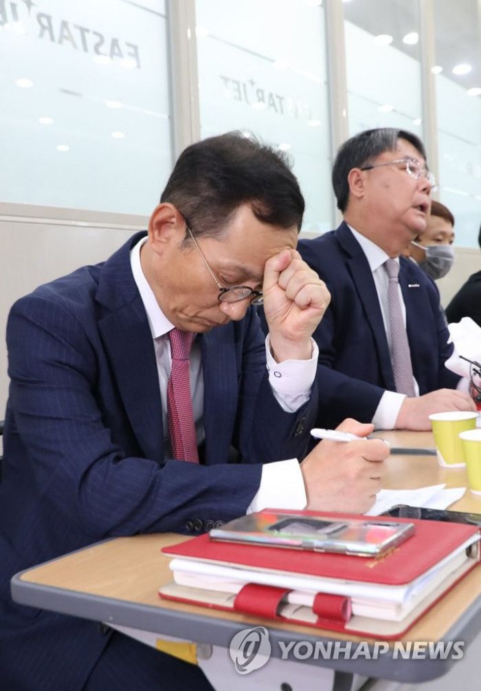 이상직 의원의 보좌관 출신인 김유상 경영기획본부장이 지난 6월 연 기자회견에서 생각에 잠겨 있다. 이날 그는 이상직 의원의 지분 헌납 성명을 대독했다. | 연합뉴스