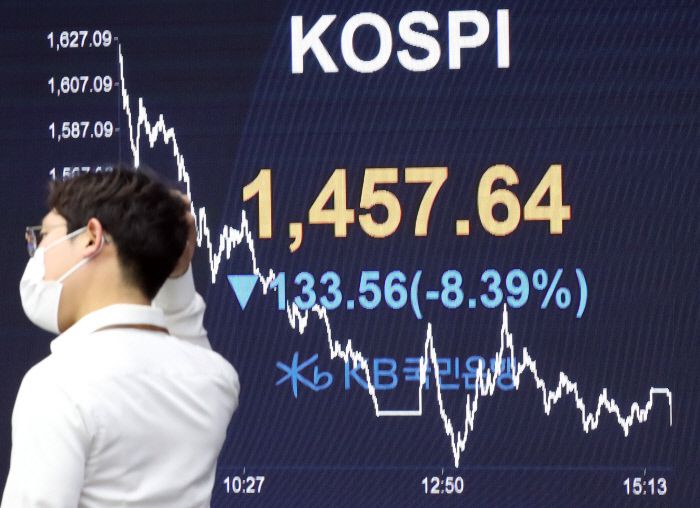 서울 영등포구 여의도 KB국민은행 딜링룸에서 지난 3월19일 한 직원이 증시 현황판 앞에 서 있다. 이날 코스피지수는 연저점인 1457.64를 기록했다. 연합뉴스