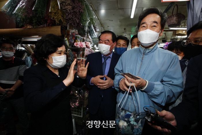 추석 연휴를 하루 앞둔 지난달 29일 서울 중구 남대문시장을 찾은 이낙연 대표가 상인에게 꽃을 선물 받은뒤 환하게 웃고 있다. /김영민 기자