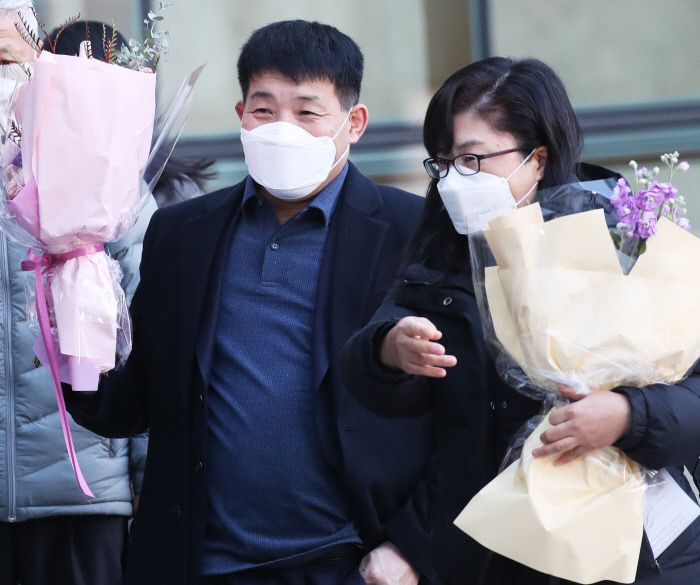 17일 오후 경기 수원시 수원지방법원에서 열린 이춘재 연쇄살인 8차 사건 재심 선고공판에서 재심 청구인 윤성여씨가 무죄를 선고받고 법원 청사를 나와 꽃다발을 받고 환하게 웃고 있다. 연합뉴스