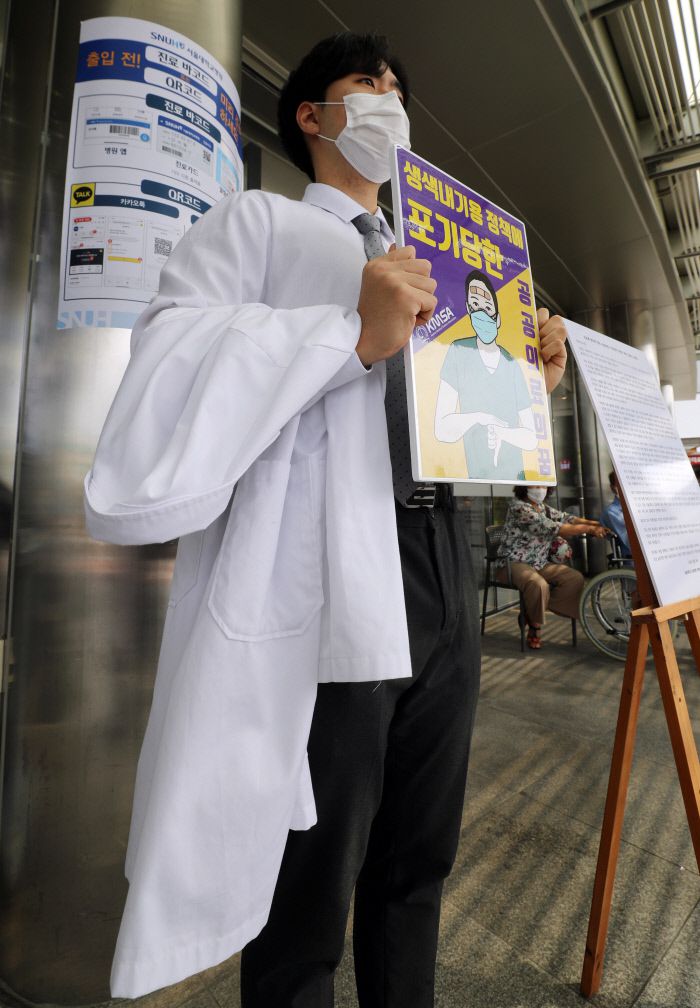 지난 8월 서울 종로구 서울대학병원 본관 앞에서 서울대 의대 3학년생이 의료계 현안 및 전공의 파업 지지 등의 내용이 담긴 성명문을 옆에 두고 릴레이 1인시위를 벌이고 있다. 연합뉴스