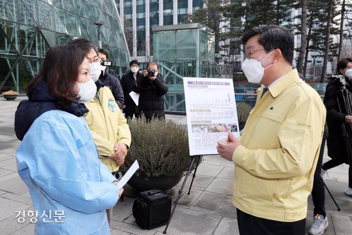 전해철 행정안전부 장관(오른쪽)이 지난해 12월 31일 서울광장 임시선별검사소를 찾아 서양호 중구청장(왼쪽)과 직원들로부터 방역대응 현장에서의 애로사항을 듣고 있다. 행정안전부 제공