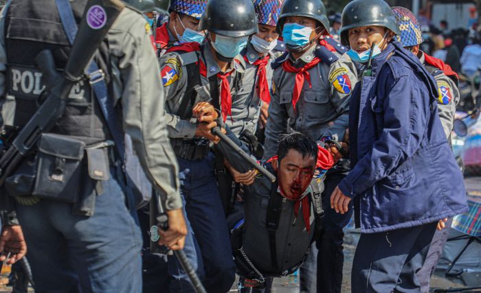 9일(현지시간) 미얀마 만달레이에서 열린 군부 쿠데타 항의 시위에 참가한 한 시민이 군경에 구타를 당해 피를 흘리면서 끌려가고 있다./로이터연합뉴스