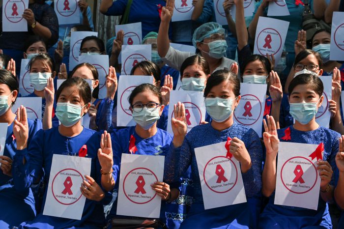 미얀마 양곤에서 시위에 참여한 학교 교사들이  빨간 리본과 세 손가락을 들어보이며 군사 쿠데타에 반대하고 있다./로이터연합뉴스