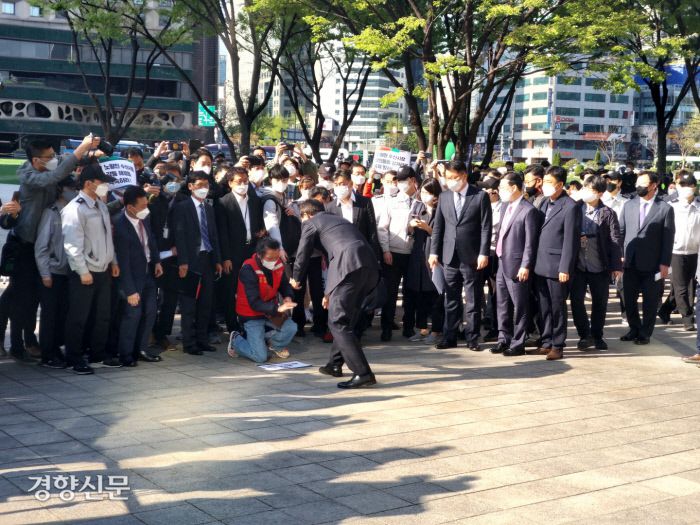 오세훈 서울시장이 8일 시청사로 출근하는 도중 민원 해결을 요구하며 엎드린 노량진 수산시장 상인을 일으켜 세우고 있다.