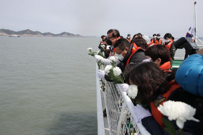 선상 추모식 세월호 참사로 숨진 안산 단원고 학생들의 유가족들이 16일 오전 전남 진도군 조도면 병풍도 인근 참사 해역에서 흰 국화를 들고 눈물을 흘리고 있다. 연합뉴스