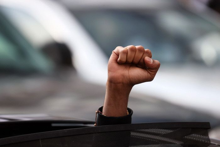 한 미국 시민이 20일(현지시간) 흑인 조지 플로이드를 사망에 이르게 한 전직 경찰관 데릭 쇼빈에 대한 유죄판결이 내려지자 주먹을 치켜들고 있다. AFP연합뉴스