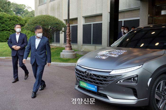 문재인 대통령이 28일 오후 청와대 여민관 앞에서 ‘2021 P4G 서울 정상회의’ 홍보 문구를 랩핑한 수소차를 둘러보고 있다. /청와대 제공