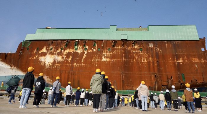 세월호 참사 7주기를 닷새 앞둔 지난 4월11일 전남 목포신항에 거치된 세월호 앞에서 유가족들이 묵념을 하고 있다. | 4·16세월호참사가족협의회 제공