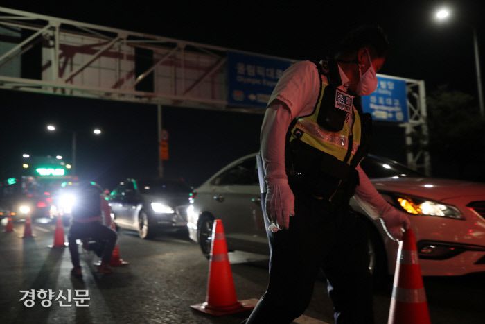 업종별 자영업자 단체들이 연합한 ‘코로나19 대응 전국자영업자비상대책위원회’가 거리두기 4단계 격상에 어려움을 호소하는 기자회견과 심야 차량시위를 예고한 14일 경찰 관계자들이 서울 영등포구 서강대교 남단에서 차량시위 통제를 위해 검문소를 설치하고 있다. 권도현 기자