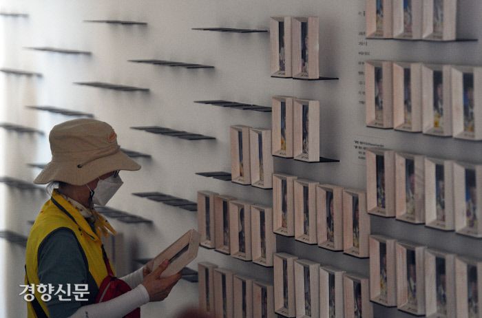 27일 오전 서울 광화문 세월호 기억공간에서 유가족 등이 세월호 참사 희생자들의 사진을 정리하고 있다.유가족은 이날 기억공간 내 물품을 서울시의회에 마련된 임시공간으로 직접 옮겼다. |사진공동취재단