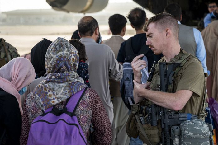미군 병사가 24일(현지시간) 아프가니스탄 카불의 하미드 카르자이 국제공항에서 이프간 피란민들의 군 수송기 탑승을 안내하고 있다. 미 공군 제공|AP연합뉴스
