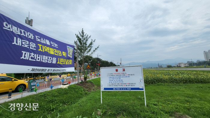 충북 제천시 모산동 제천비행장에 군부대가 세운 경고문과 시민들이 제천비행장을 돌려달라는 펼침막이 걸려있다. 이삭 기자.
