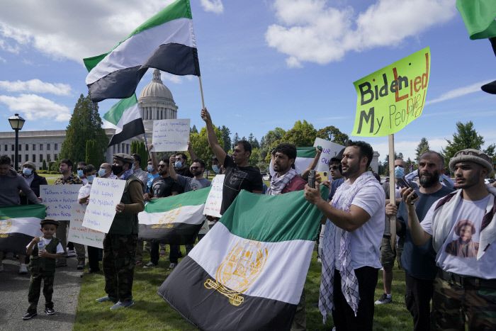 미국 워싱턴주 올림피아에서 8일(현지시간) 열린 탈레반 정부와 탈레반을 지원한 파키스탄을 비판하는 집회 참가자들이 과거 1990년대 중반 탈레반에게 붕괴되기 전 아프간 정부가 사용했던 국기를 흔들면서 미국 정부는 탈레반 정부를 승인해선 안된다고 주장하고 있다. 올림피아|AP연합뉴스