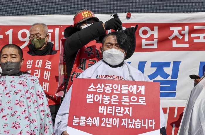 15일 오후 서울 광화문 열린마당에서 열린 ‘코로나19 피해 실질 보상 촉구 정부 규탄대회’에서 자영업자들이 삭발식을 하고 있다. 연합뉴스