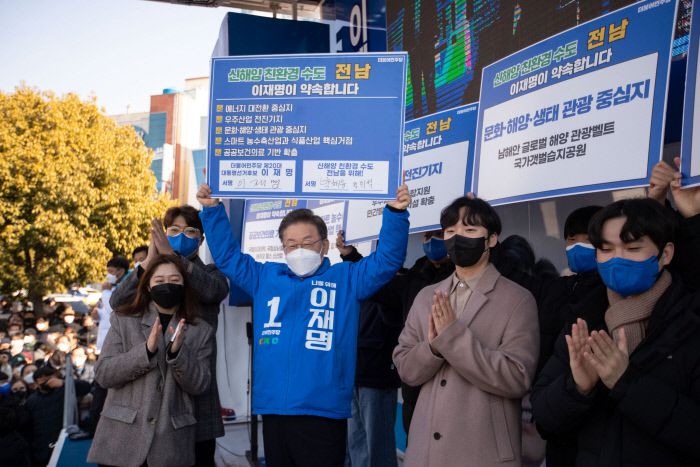 이재명 더불어민주당 대선 후보가 18일 전남 목포시 평화광장에서 열린 ‘김대중 대통령님, 그립습니다’ 목포 유세에서 지역청년들과 지역 공약 서명 피켓을 들고 있다. 공동취재