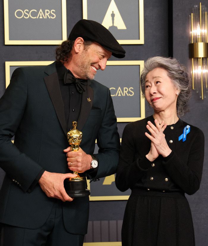 <코다>의 트로이 코처가 27일(현지시간) 열린 제94회 아카데미 시상식에서 남우조연상을 받은 뒤 사진촬영에 응하고 있다. 이날 시상한 윤여정이 착용한 푸른 리본은 유엔난민기구의 난민 캠페인에 대한 지지를 의미한다. 로이터연합뉴스