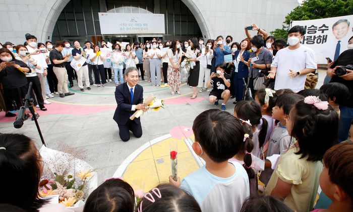 김승수 전주시장이 30일 열린 퇴임식에서 어린이들의 축하를 받자 무릎을 꿇고 눈높이에 맞춰 감사인사를 하고 있다. 전주시 제공