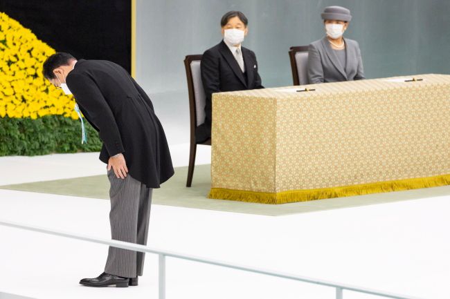 기시다 후미오 일본 총리(왼쪽)가 일본의 2차 세계대전 패배 77주년인 15일 도쿄 부도칸에서 열린 전국 전몰자 추도식에서 나루히토 일왕 부부가 지켜보는 가운데 헌화 후 묵념하고 있다. 도쿄 | EPA연합뉴스