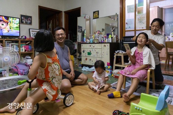 연희(6)랑 이야기 하는 종수씨와 독서삼매경에 빠진 17개월 막내 은재, 첫째 연아(9)의 머리카락을 잘라주는 은영씨.