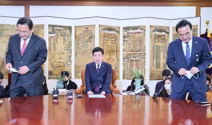 김진표 국회의장(가운데)이 지난 14일 오전 국회 의장실에서 주호영 국민의힘 원내대표(왼쪽), 박홍근 더불어민주당 원내대표와 기념촬영 뒤 자리에 앉고 있다. 연합뉴스