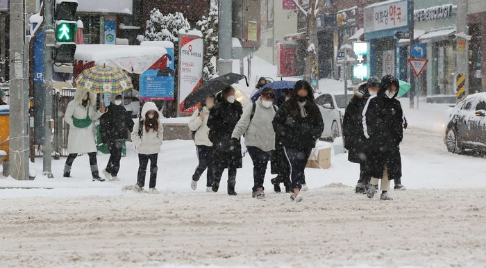 광주·전남에 대설경보가 발효된 23일 폭설이 내리면서 광주 남구의 한 도로에서 직장이나 학교로 향하는 시민들이 힘겨운 발걸음을 옮기고 있다. 연합뉴스
