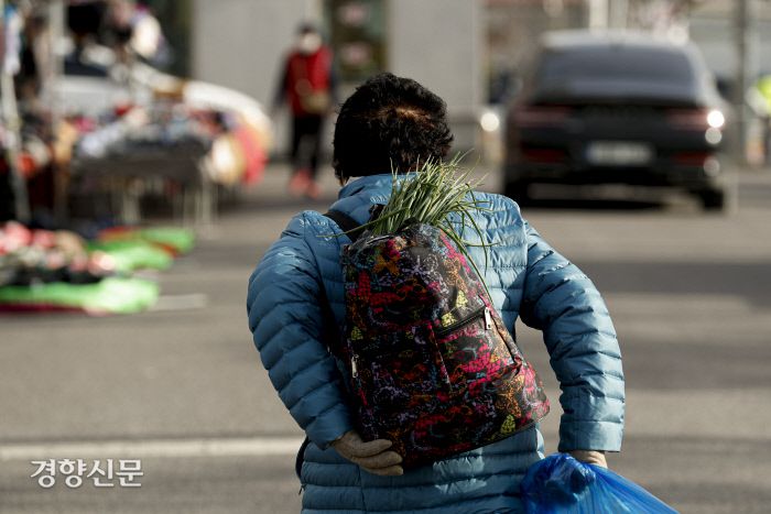 한 할머니가 부추가 가득 담긴 가방을 메고 버스 정류장으로 향하고 있다. 문재원 기자