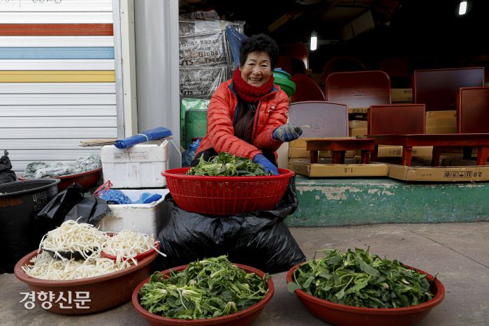 골목길 좌판에서 한 상인이 시금치를 다듬고 있다. 문재원 기자