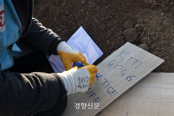 튀르키예·시리아 대지진 8일째인 13일(현지시간) 튀르키예 남부 카라만마라슈의 남쪽 교외의 한 공터에서 한 관계자가 나무 묘비에 이름을 적고 있다. 카라만마라슈(튀르키예)｜문재원 기자