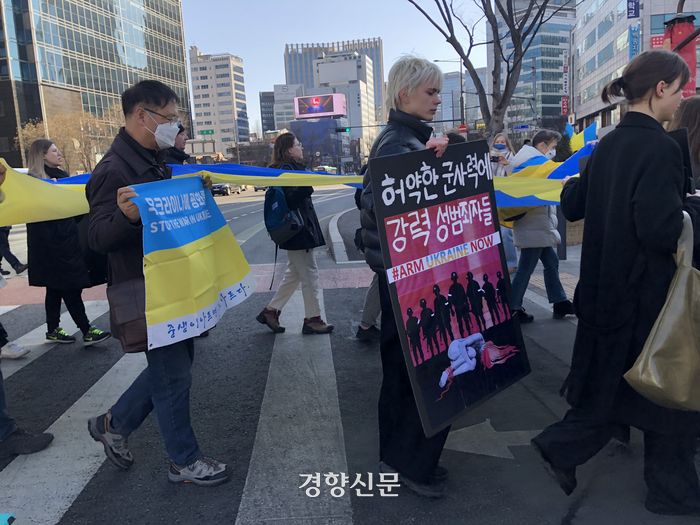 19일 오후 서울 중구 주한러시아대사관 인근에 모인 우크라이나인들이 전쟁 중단을 외치며 우크라이나 국기를 들고 행진하고 있다.