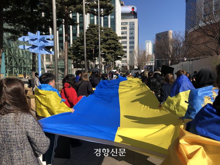 19일 오후 서울 중구 주한러시아대사관 인근에 모인 우크라이나인들이 전쟁 중단을 외치며 우크라이나 국기를 들고 행진하고 있다.