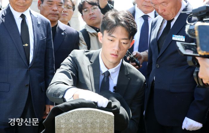 전우원씨가 자신의 외투를 벗어 고 김경철 열사 묘비를 닦고 있다.