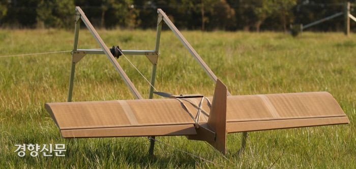 SYPAQ 시스템즈의 종이 드론이 들판에서 이륙을 대기하고 있다. 하늘로 튕기듯 이륙한 뒤 동력은 전면에 부착된 프로펠러에서 얻는다. SYPAQ 제공