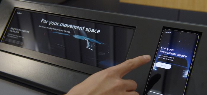 ‘기아 EV 언플러그드 그라운드’에서 고객이 ‘기아 커넥트 스토어’를 체험하고 있다.  연합뉴스