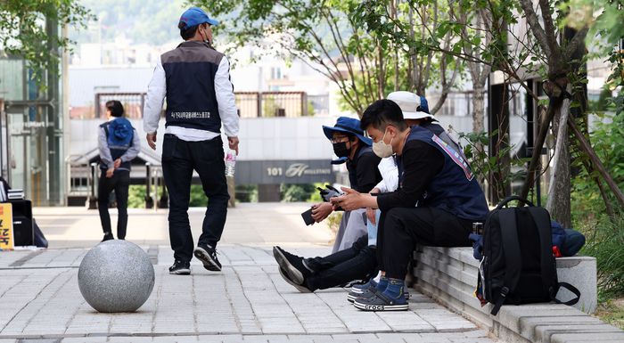 경찰의 강제 해산에도 노숙 농성을 강행한 금속노조와 비정규직 노동단체 ‘비정규직 이제그만 공동투쟁’ 관계자들이 26일 오전 서울 서초구 대법원 정문 맞은편 공원에 앉아있다. 연합뉴스