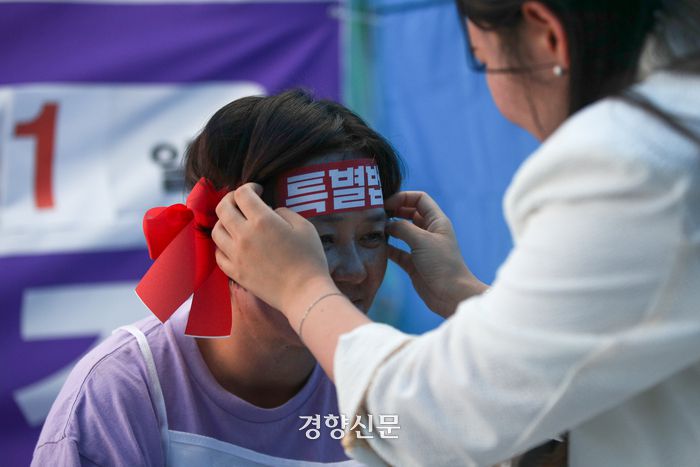 이태원 참사 희생자 고 박가영씨의 어머니 최선미씨가 20일 서울 국회 앞에서 이태원 참사 특별법 제정을 촉구하는 유가족 단식 농성을 시작하며 머리띠를 고쳐 매고 있다. 성동훈 기자