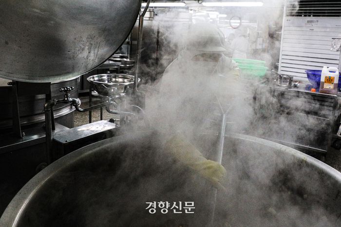 한 급식 조리사가 조리용 삽으로 돼지갈비찜을 뒤집고 있다. 몸보다 큰 솥 앞에 서서 뜨거운 김을 맞으며 삽질을 하는 모습이 힘겨워 보인다. 성동훈 기자