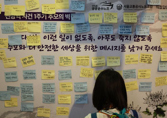 신당역 스토킹 살인사건 1주기를 맞은 14일 저녁 서울 신당역 10번 출구에 마련된 추모공간을 찾은 시민이 추모 메시지를 적고 있다. 연합뉴스