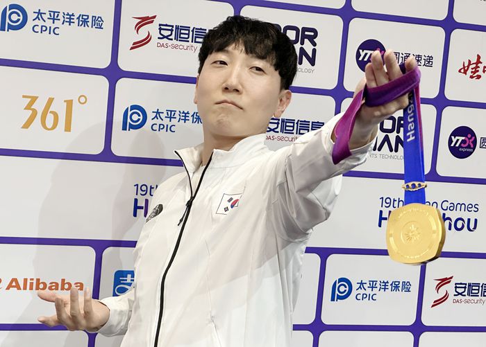 김관우가 28일 중국 항저우 e스포츠센터에서 열린 2022 항저우 아시안게임 스트리트 파이터 V 결승전에서 대만의 샹여우린을 세트 점수 4-3으로 물리치고 금메달을 획득한 뒤 공동취재구역(믹스트존)에서 취재진을 향해 포즈를 취하고 있다. 연합뉴스