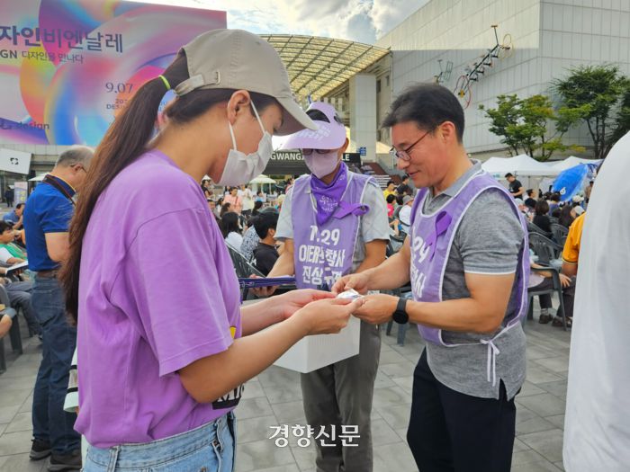 이종민씨가 광주 비엔날레 광장에서 시민들에게 이태원 참사를 기리는 보라리본을 나눠주고 있다. 김송이 기자