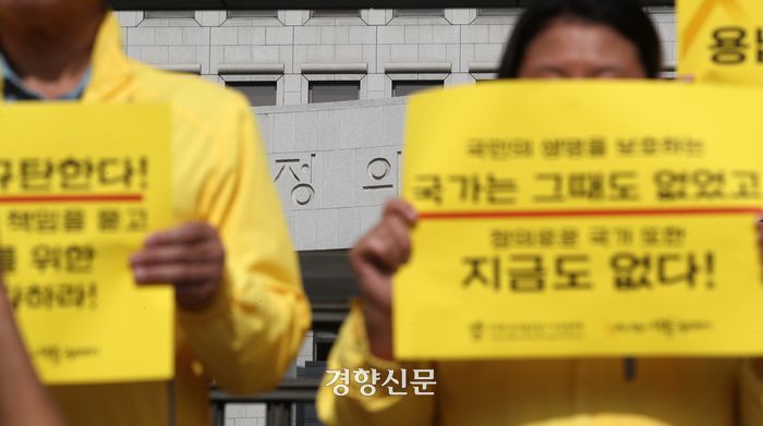세월호 참사 유가족들이 기자회견에서 대법원을 규탄하는 손팻말을 들고 있다.