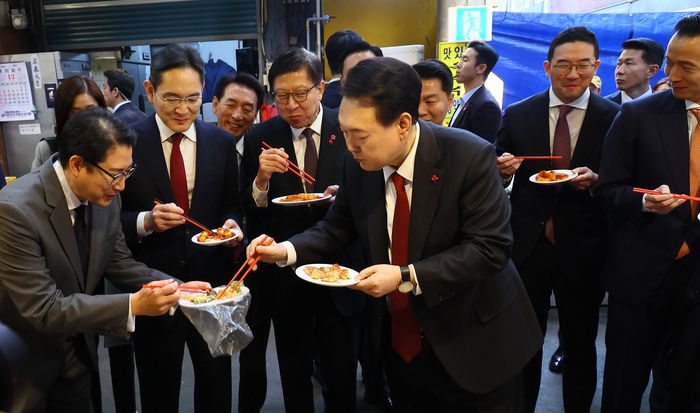 윤석열 대통령과 이재용 삼성전자 회장 등이 6일 부산 중구 깡통시장을 방문해 떡볶이를 시식하고 있다. 이날 부산항 국제 전시컨벤션센터에서 열린 ‘부산시민의 꿈과 도전’ 격려 간담회를 마친 뒤 재계 총수들과 이곳을 찾은 윤 대통령은 경기침체로 어려움을 겪고 있는 상인들을 응원하고 격려했다. 대통령실사진기자단