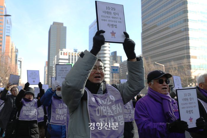 이태원 참사 특별법 제정을 촉구하며 국회로 향하는 행진에서 참가자들이 특별법을 들어올리며 구호를 외치고 있다.