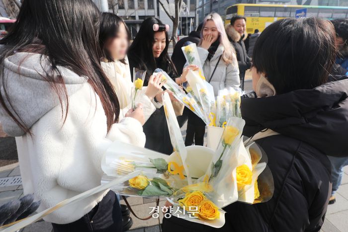 세월호 참사 10주기 위원회 소속 활동가들이 시민들에게 노랑 장미를 나눠주고 있다.