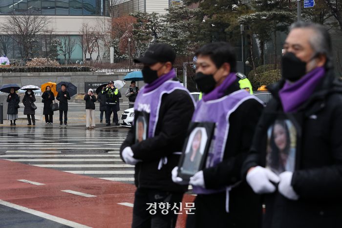 10·29 이태원 참사 유가족협의회와 시민대책회의 관계자들이 17일 서울광장 분향소에서 출발해 특별법 공포와 독립적 조사기구 설립을 촉구하며 희생자들의 영정을 들고 용산 대통령실 방향으로 행진하자 시민들이 발걸음을 멈추고 그 모습을 지켜보고 있다.